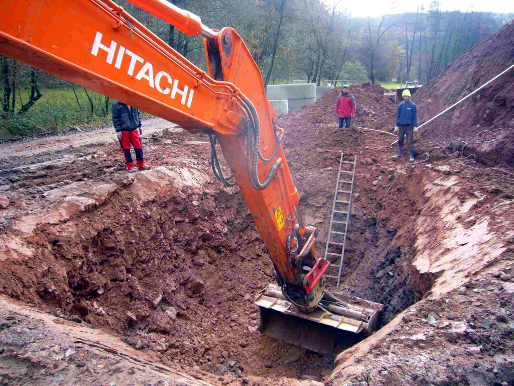 Der Bagger gräbt das tiefe Loch für die Klärgrube